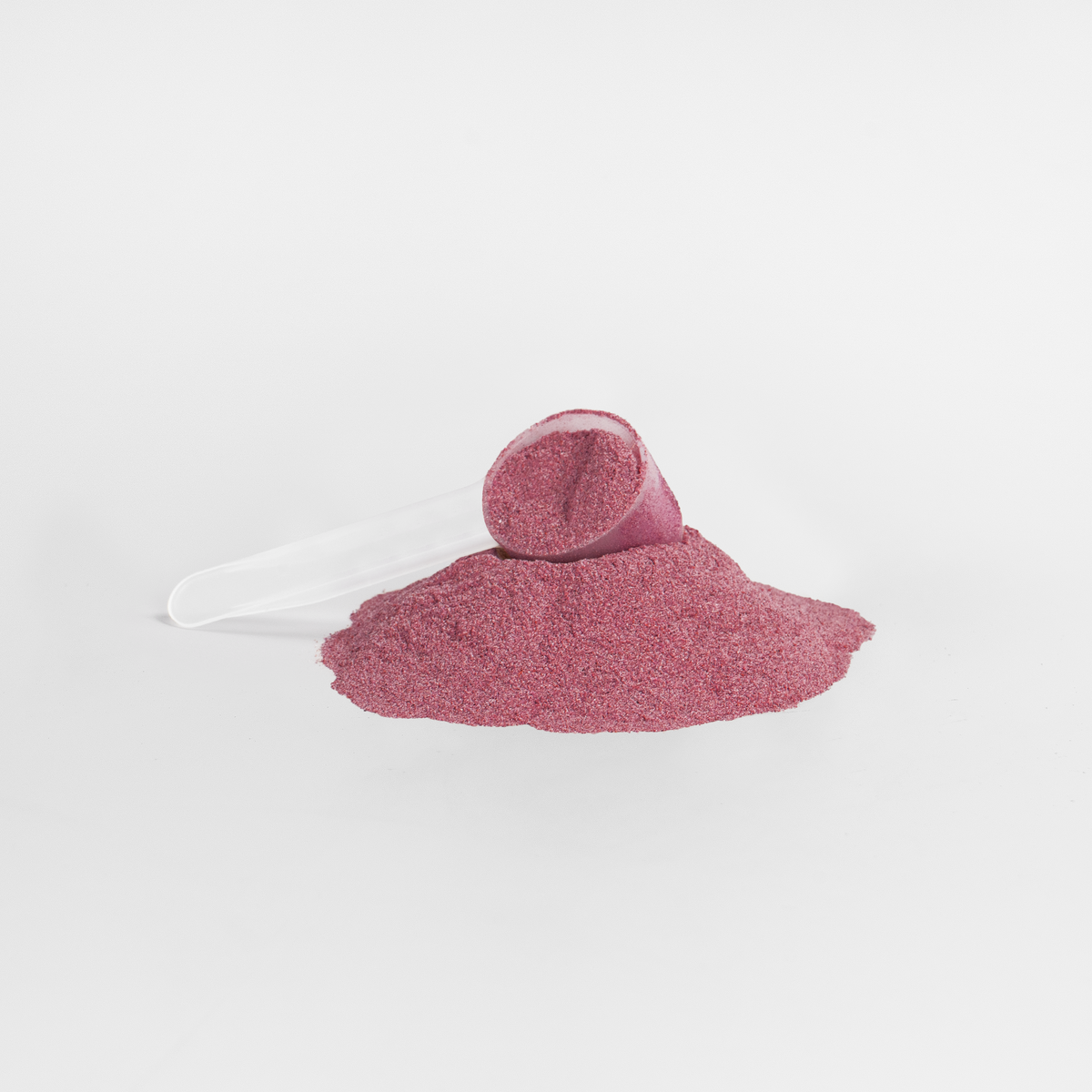 Close-up of NUTRIO Vital Beets pink superfood powder with a clear measuring scoop