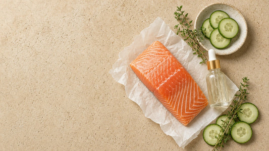 Fresh salmon fillet beside a serum dropper bottle, cucumber slices and thyme