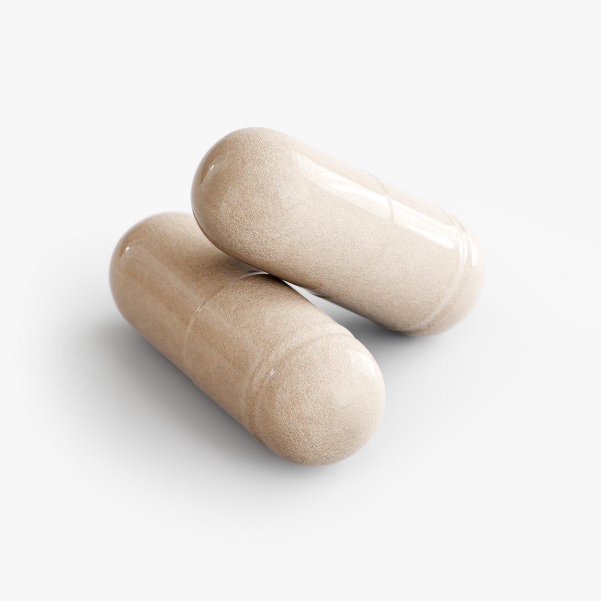 Close-up of two beige NUTRIO Daily Complete Multivitamin capsules